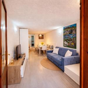 a living room with a blue couch and a television at Tortuga Smeralda in Porto Rotondo
