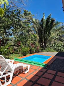 a swimming pool with two lawn chairs and a swimming pool at Villas Pura Vida - Mango in Puntarenas