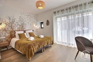 a bedroom with a bed and a large window at Le val d'ic in Pordic