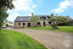 a stone house with a driveway in front of it at Le val d'ic in Pordic