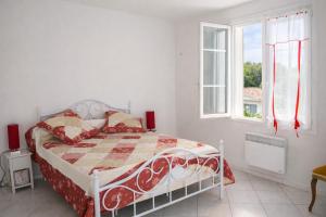 a white bedroom with a bed and a window at Appartement calme grande terrasse 150 m de la plage in Meschers-sur-Gironde
