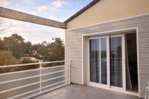 a balcony with sliding glass doors on a house at Appartement calme grande terrasse 150 m de la plage in Meschers-sur-Gironde