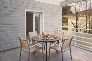 a table with chairs and food on a patio at Appartement calme grande terrasse 150 m de la plage in Meschers-sur-Gironde