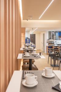 a cafeteria with tables and chairs and coffee cups at Hotel 64 Nice in Nice +48 photos