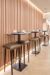 a row of tables and stools in a restaurant at Hotel 64 Nice in Nice