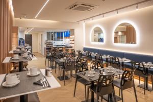 a dining room with tables and chairs and a kitchen at Hotel 64 Nice in Nice