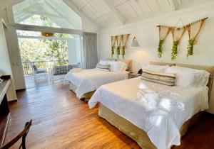 a bedroom with two beds and a balcony at Finca San Cayetano in San Juan Alotenango