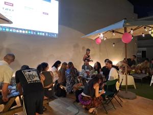 a group of people sitting around a table at a presentation at Tilia Hostel in Faro