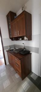 a kitchen with a sink and wooden cabinets at Apartmani Palma in Sutomore +20 photos