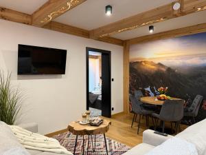 a living room with a large painting on the wall at GreenHill Bachleda in Zakopane