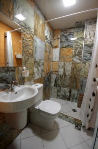 y baño con aseo, lavabo y ducha. en Guest House "The House" Топ Център Габрово, en Gabrovo
