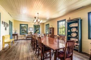 a dining room with a wooden table and chairs at Historic Bliss on Pawleys Island's Shoreline in Pawleys Island +29 photos