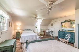 a bedroom with two beds and a desk and a ceiling fan at Historic Bliss on Pawleys Island's Shoreline in Pawleys Island