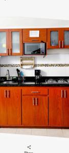 a kitchen with wooden cabinets and a sink at Tu Estancia en Cali - Valle del Lili in Cali