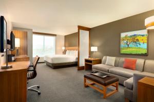 a hotel room with a couch and a bed at Hyatt Place Vacaville in Vacaville