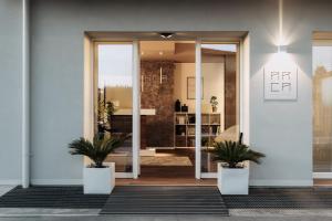 a lobby with two potted plants in front of a door at Arca Guest House in San Trovaso