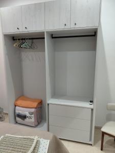 a white closet with a bed and a chair at Charming Ground-floor Maisonette in Birgu