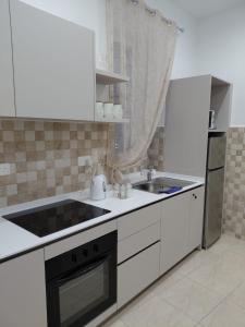 a white kitchen with a sink and a refrigerator at Charming Ground-floor Maisonette in Birgu +14 photos