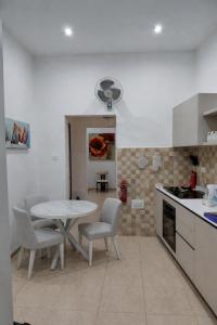 a kitchen with a table and chairs in a room at Charming Ground-floor Maisonette in Birgu