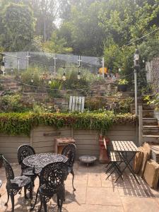 a patio with a table and chairs and a garden at Calderbrook House in Hebden Bridge