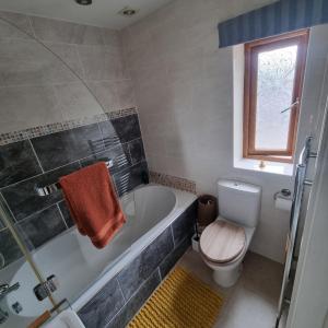 a bathroom with a tub and a toilet and a sink at Calderbrook House in Hebden Bridge +17 photos