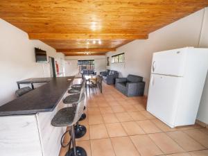 a kitchen with a white refrigerator and a table at Impala Game Ranch in Dinokeng Game Reserve
