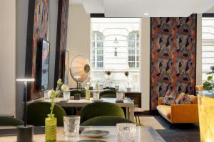 a room with green chairs and a table with a mirror at Radisson Blu Style Hotel, Vienna in Vienna