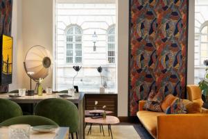 a living room with a couch and a table and chairs at Radisson Blu Style Hotel, Vienna in Vienna