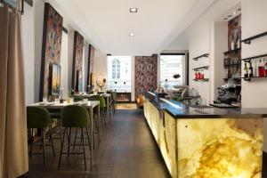 a restaurant with a bar with green chairs at Radisson Blu Style Hotel, Vienna in Vienna