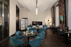 a dining room with tables and blue chairs at Radisson Blu Style Hotel, Vienna in Vienna +65 photos