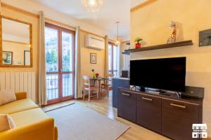 a living room with a flat screen tv and a couch at AL LAGO by Design Studio in Bellano