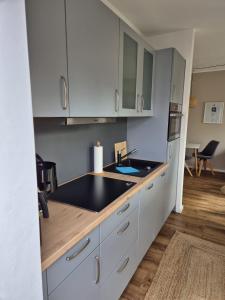 a kitchen with white cabinets and a sink at Kleine Hafenperle Büsum in Büsum
