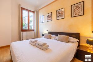 a bedroom with a white bed with towels on it at AL LAGO by Design Studio in Bellano