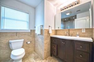 a bathroom with a toilet and a sink and a mirror at Waterfront oasis 3BR Game Room Pet Friendly in Little Egg Harbor Township