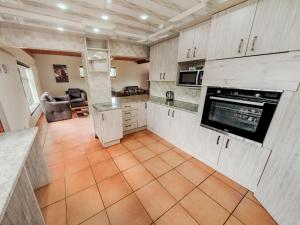 a kitchen with white cabinets and an orange tile floor at Impala Game Ranch in Dinokeng Game Reserve