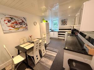 a kitchen with a table and chairs in a kitchen at Paisley Pad Glasgow Gateway second floor flat in Paisley