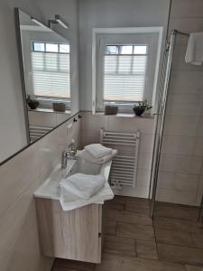 a bathroom with a sink and a mirror at Kleine Hafenperle Büsum in Büsum