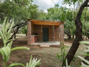 a brick building with a green door in a park at Impala Game Ranch in Dinokeng Game Reserve