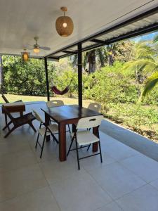 a dining room with a table and chairs and a hammock at Villas Pura Vida - Marañón in Puntarenas