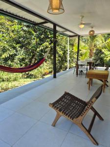 a porch with a hammock and a table at Villas Pura Vida - Marañón in Puntarenas