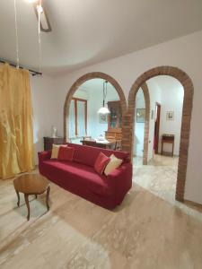 a living room with a red couch and a table at I Tre Archi in Suvereto