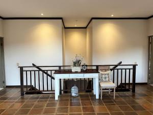a table with a vase of flowers and two chairs at Periwinkle Blue in Clarens