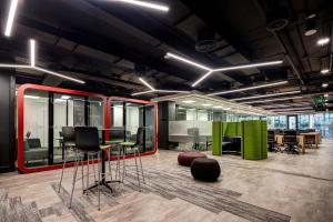 ein Büro mit Schreibtischen und Stühlen in einem Raum in der Unterkunft Hotel Nodo - El primer hotel de negocios en Chile in Santiago