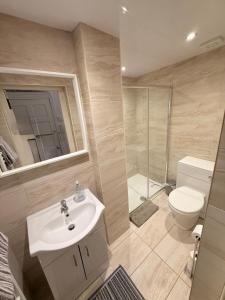 a bathroom with a sink and a toilet and a shower at Paisley Pad Glasgow Gateway second floor flat in Paisley +10 photos