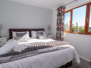 a bedroom with a large white bed with a window at Star Carr Lakes in Great Driffield