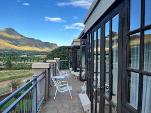 a balcony of a house with a view of mountains at Periwinkle Blue in Clarens