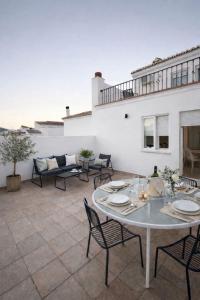 a patio with a table and chairs and a couch at Avanel Boutique Apartments in Ronda
