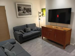 a living room with a couch and a flat screen tv at Dale combe in Middleton