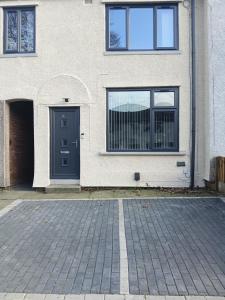 a house with a blue door and a brick driveway at Dale combe in Middleton