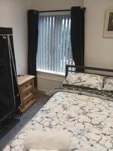 a bedroom with a bed and a window with curtains at Dale combe in Middleton